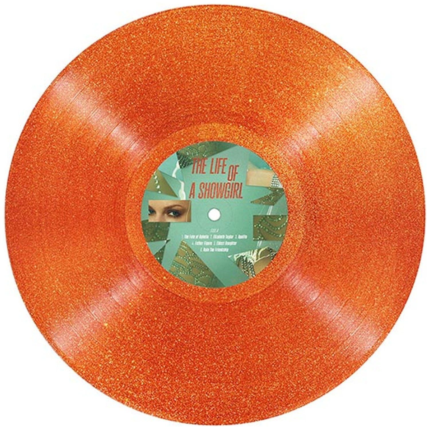 Disque vinyle orange à paillettes. L'étiquette centrale porte le texte 'The Life of a Showgirl' et les yeux d'une femme.