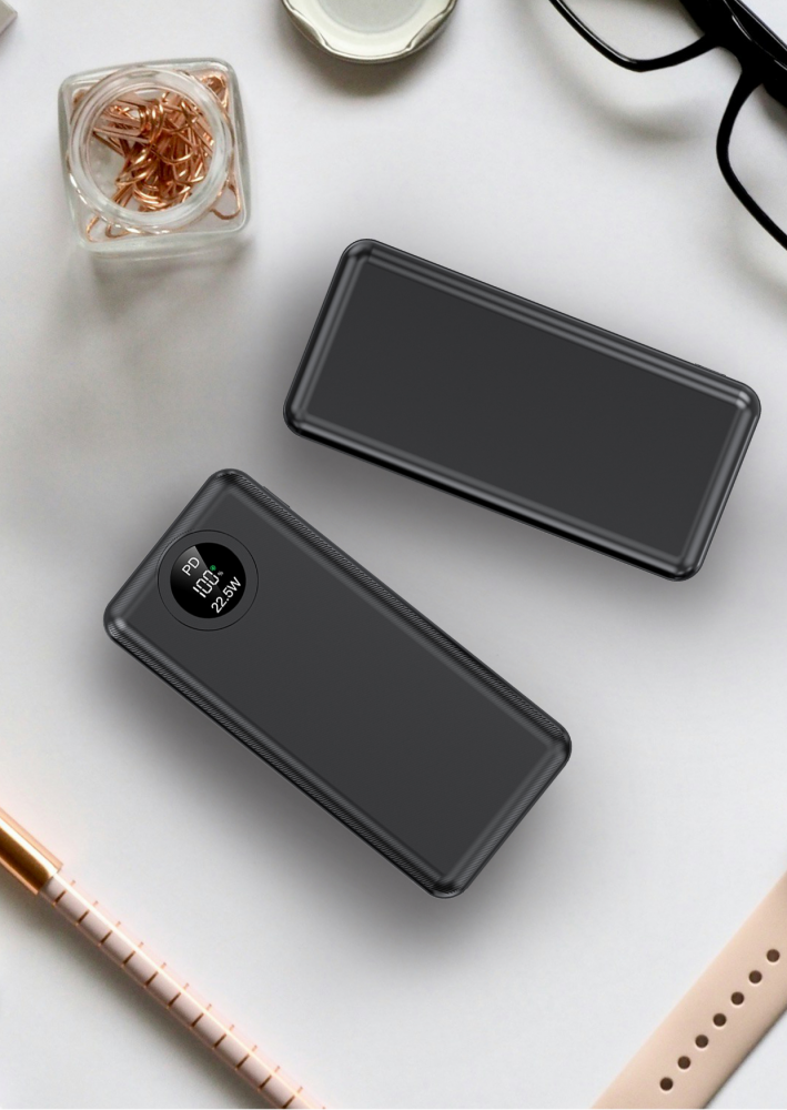 Két fekete power bank egy fehér felületen, kiegészítőkkel, mint a gemkapocs üveg és egy óraszíj.