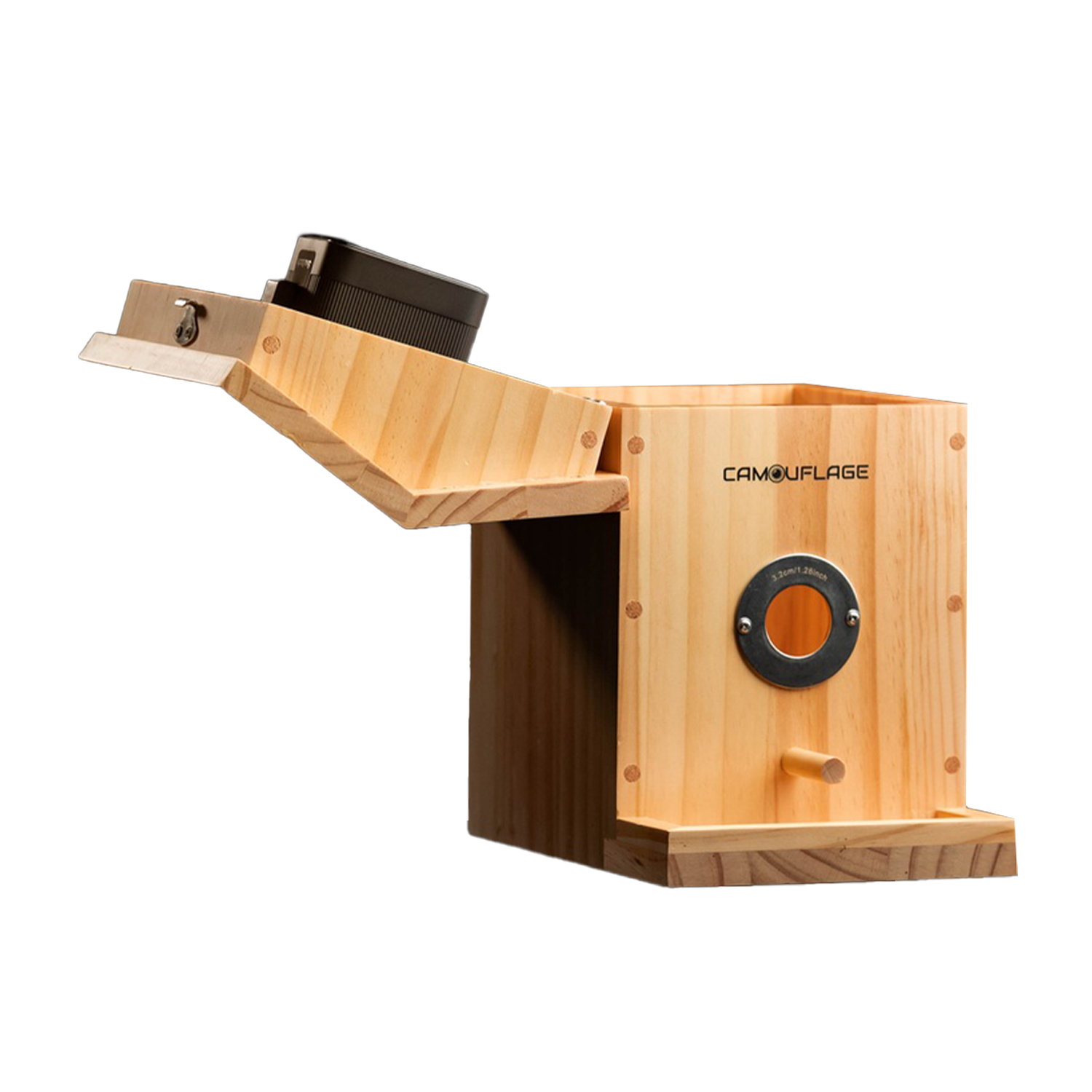 Una scatola di legno con coperchio incernierato e apertura circolare. Una fotocamera nera è montata sul coperchio. La scatola è etichettata 'CAMOUFLAGE'.