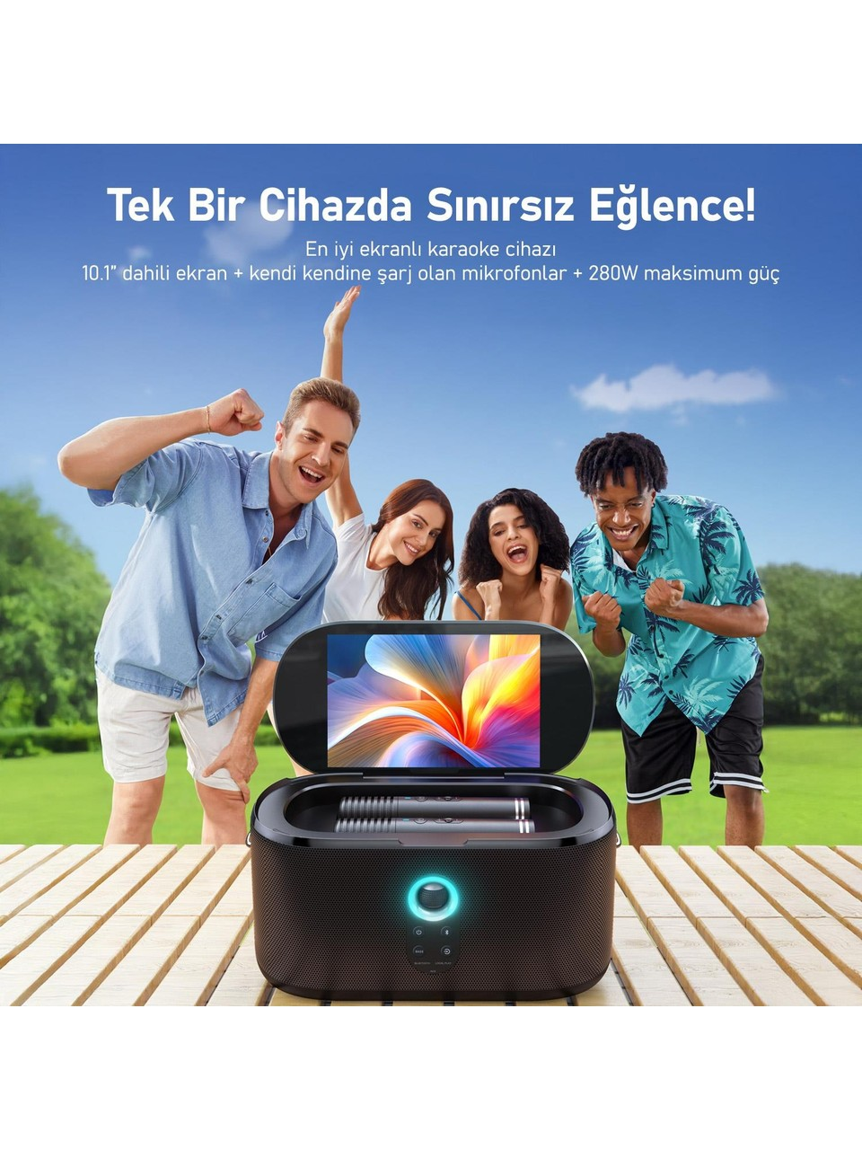 Dört kişi bir karaoke makinesinin etrafında kutlama yapıyor. Cihaz, bahçedeki ahşap bir masanın üzerinde duruyor. Arka planda mavi gökyüzü.