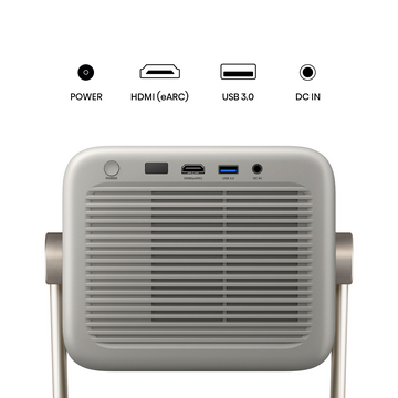 Vista trasera de un proyector beige con puertos de alimentación, HDMI, USB y DC IN, y un asa dorada.