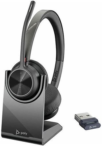 Ein schwarzes Poly Voyager-Headset mit Ladestation und USB-Dongle. Das Headset hat ein Mikrofon und das Poly-Logo auf dem Ständer.