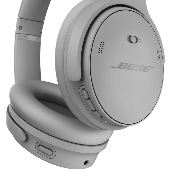 Zbliżenie szarych słuchawek Bose. Prawy nausznik pokazuje przyciski głośności i logo Bose. Słuchawki są na białym tle.