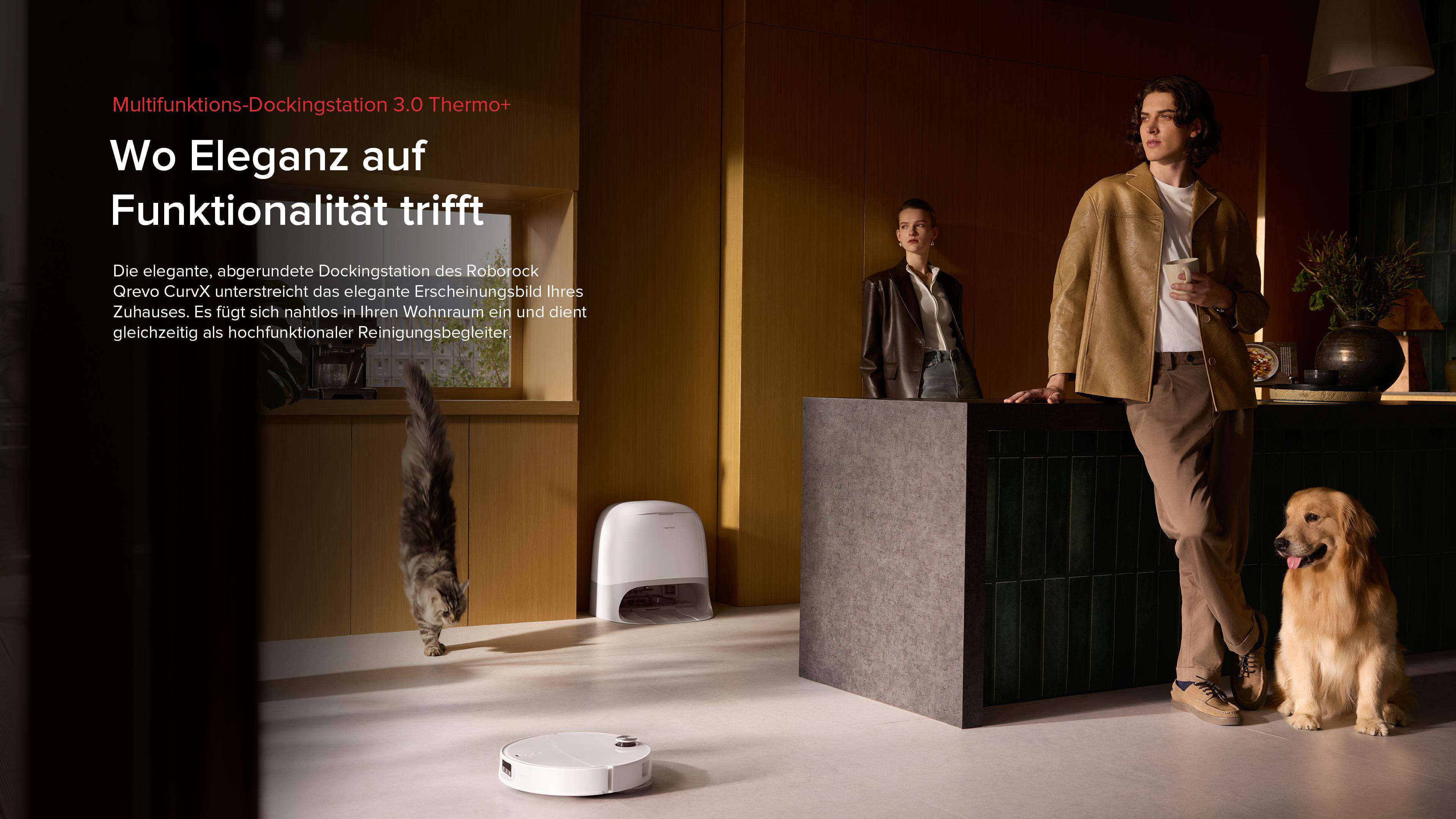 Ein Mann und eine Frau stehen an einer Theke mit einem Hund, einer Katze und einem Roboterstaubsauger.