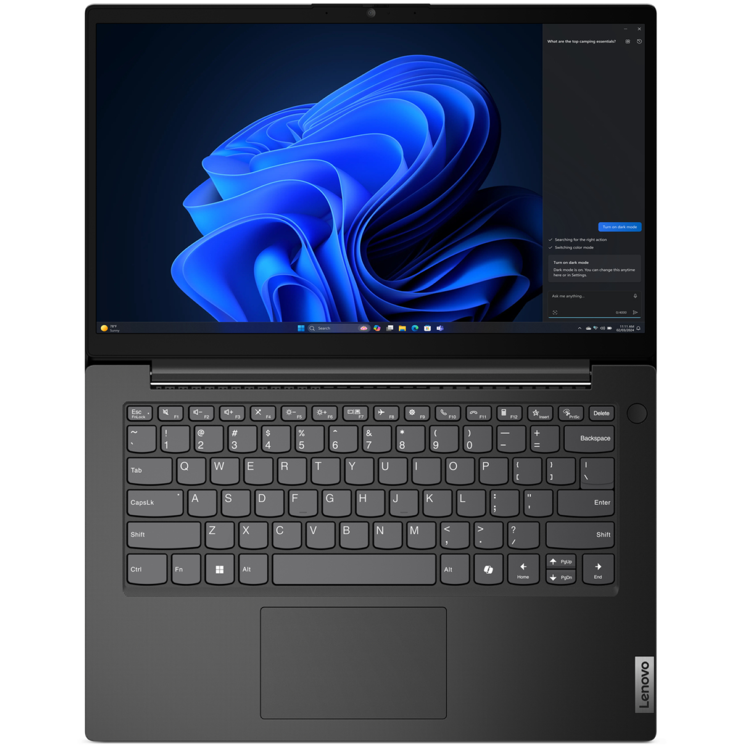 Laptop with Windows 11. The screen shows a blue abstract image with a search bar and dark mode options.