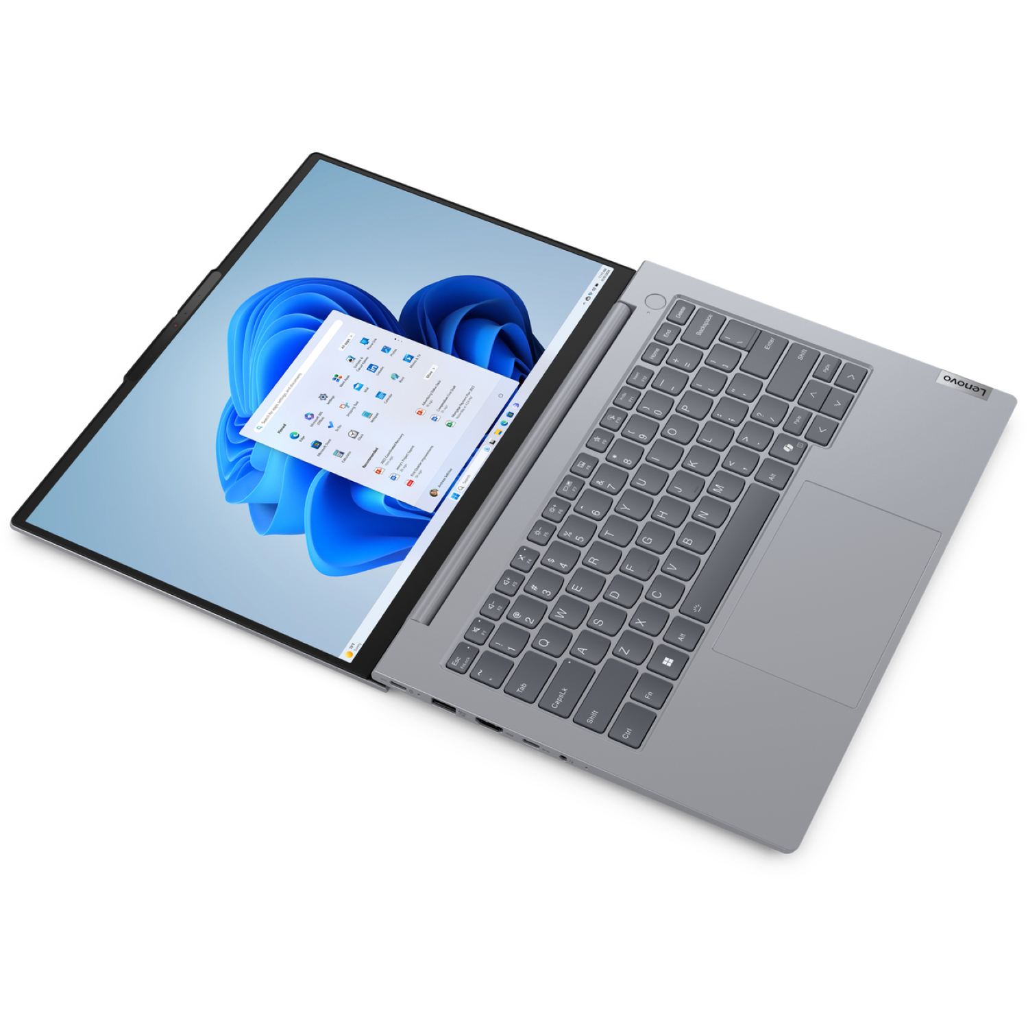 A gray Lenovo laptop is open, displaying a Windows 11 interface. The screen shows app icons and a blue abstract background.