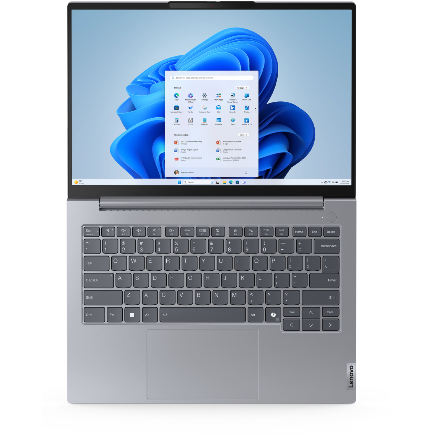 Silver Lenovo laptop open, showing Windows 11 interface with apps and a blue abstract background.