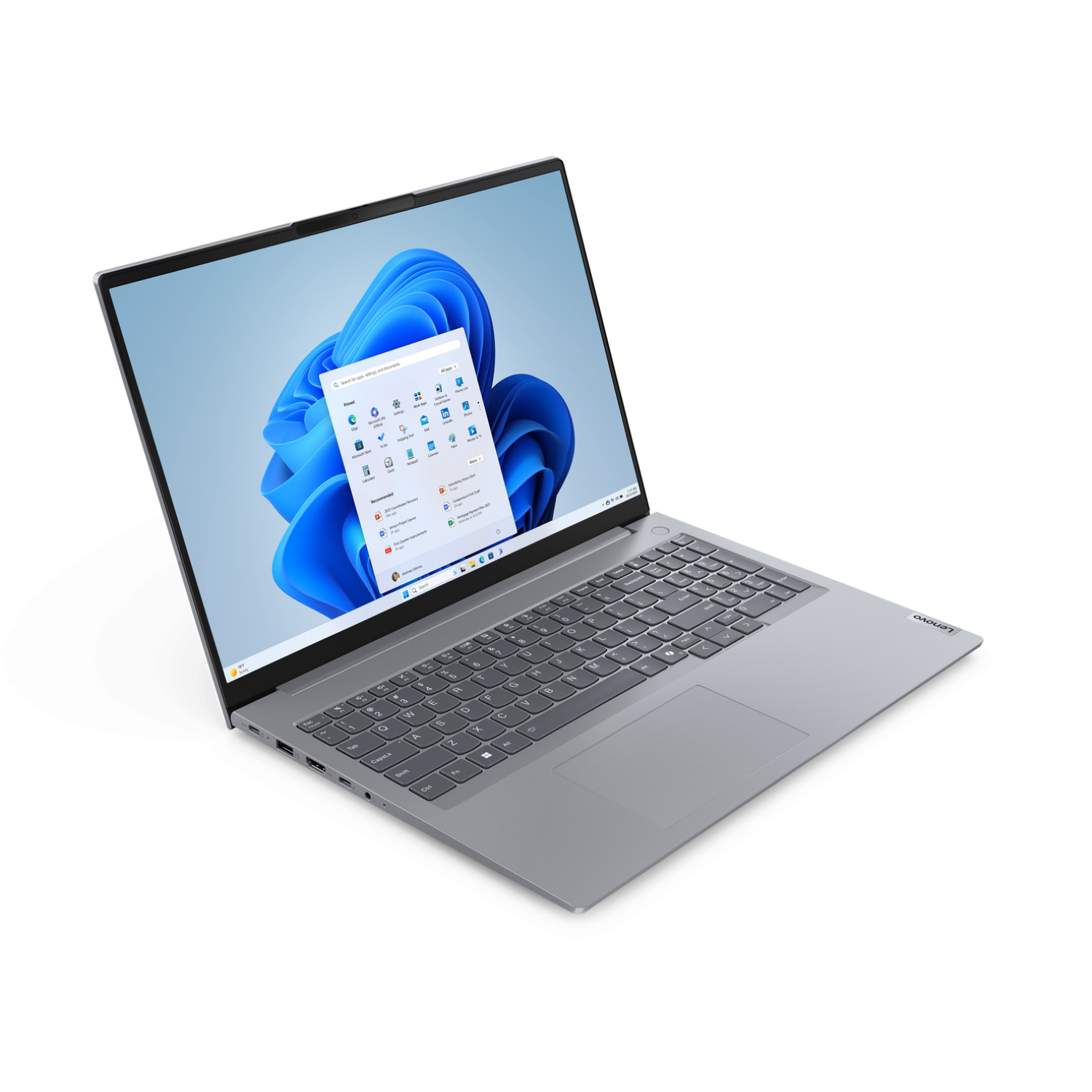 A silver Lenovo laptop is open, displaying the Windows 11 interface. The screen shows the start menu with app icons, and a blue background.