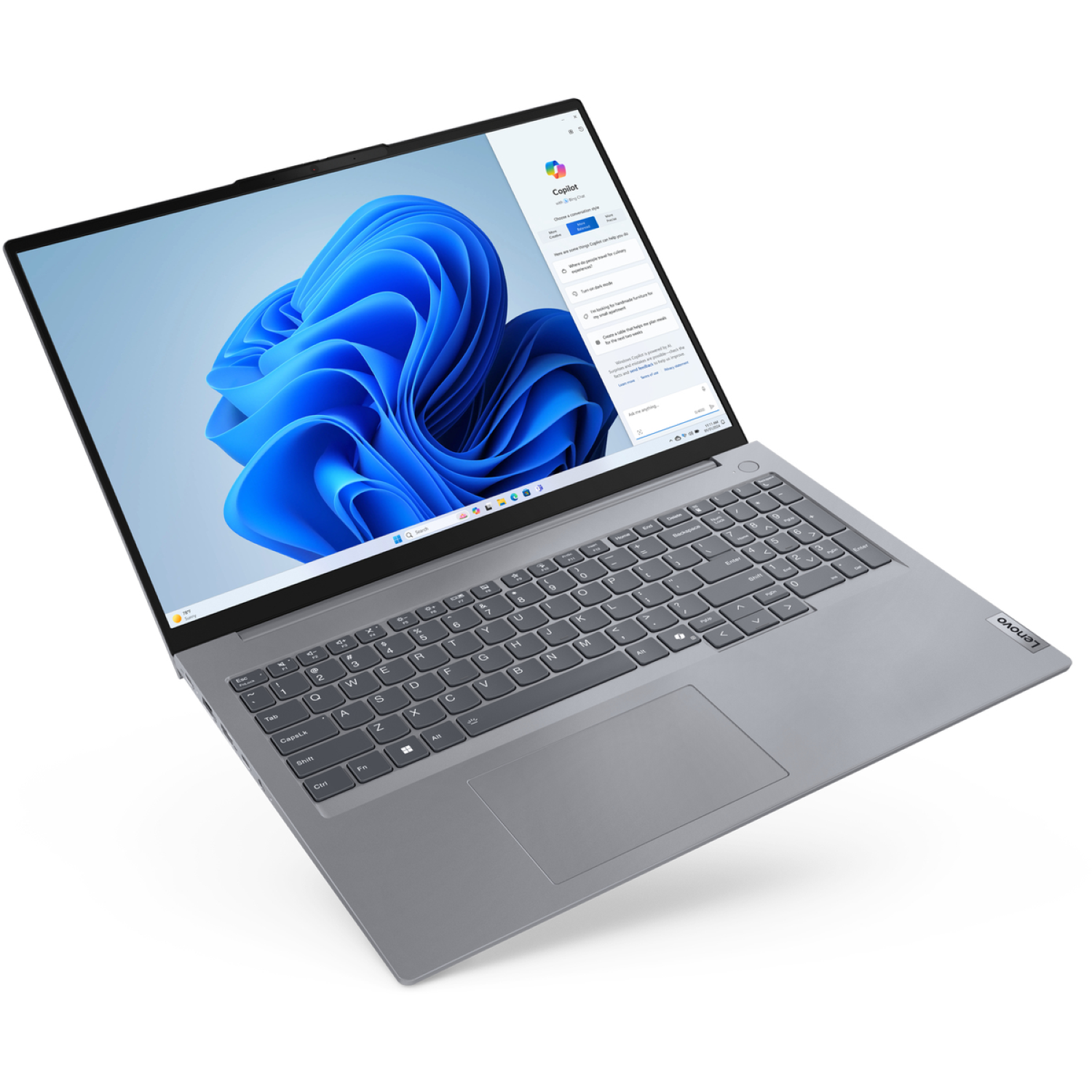 A gray Lenovo laptop is open, displaying a Windows 11 interface with a blue swirl background and a Copilot application.