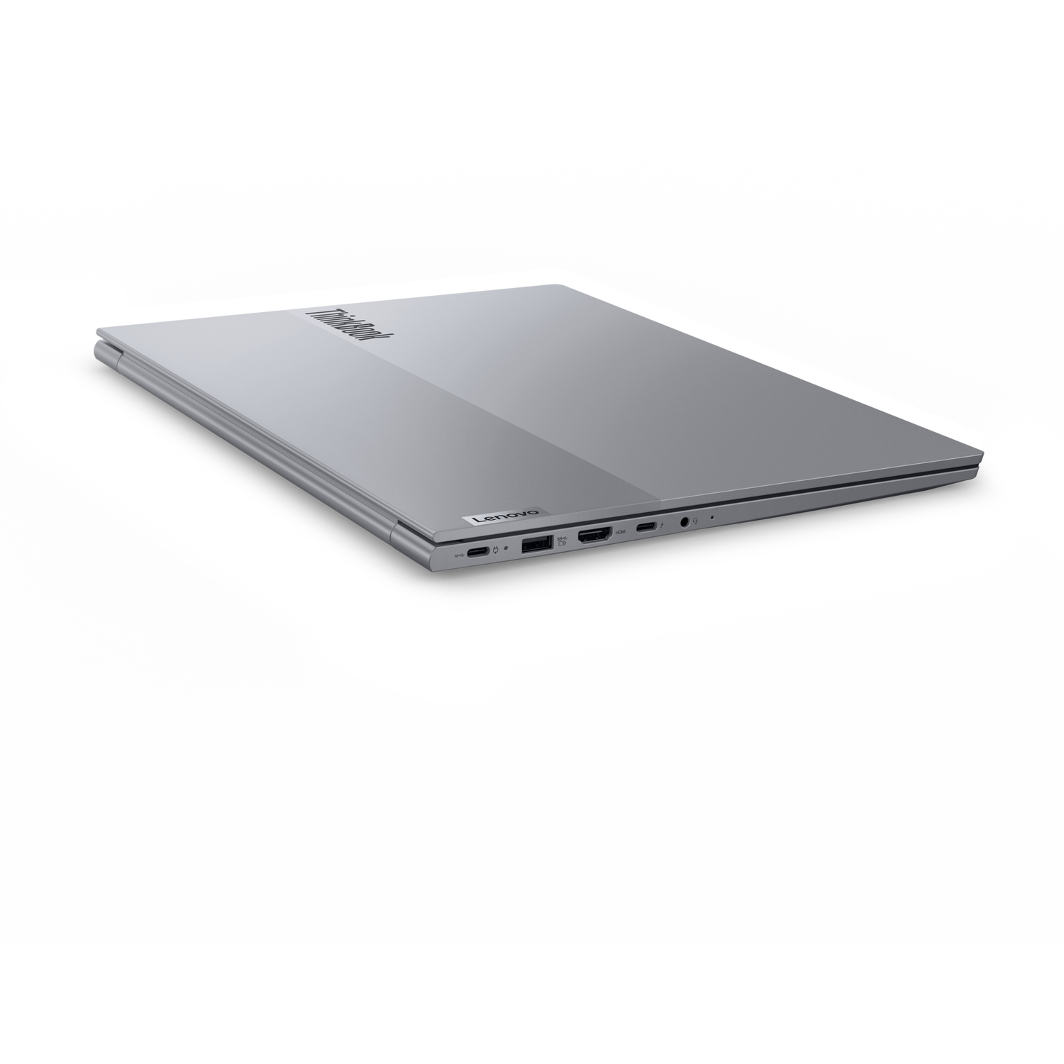 A closed silver Lenovo ThinkBook laptop is angled on a white surface. The ThinkBook logo is visible.