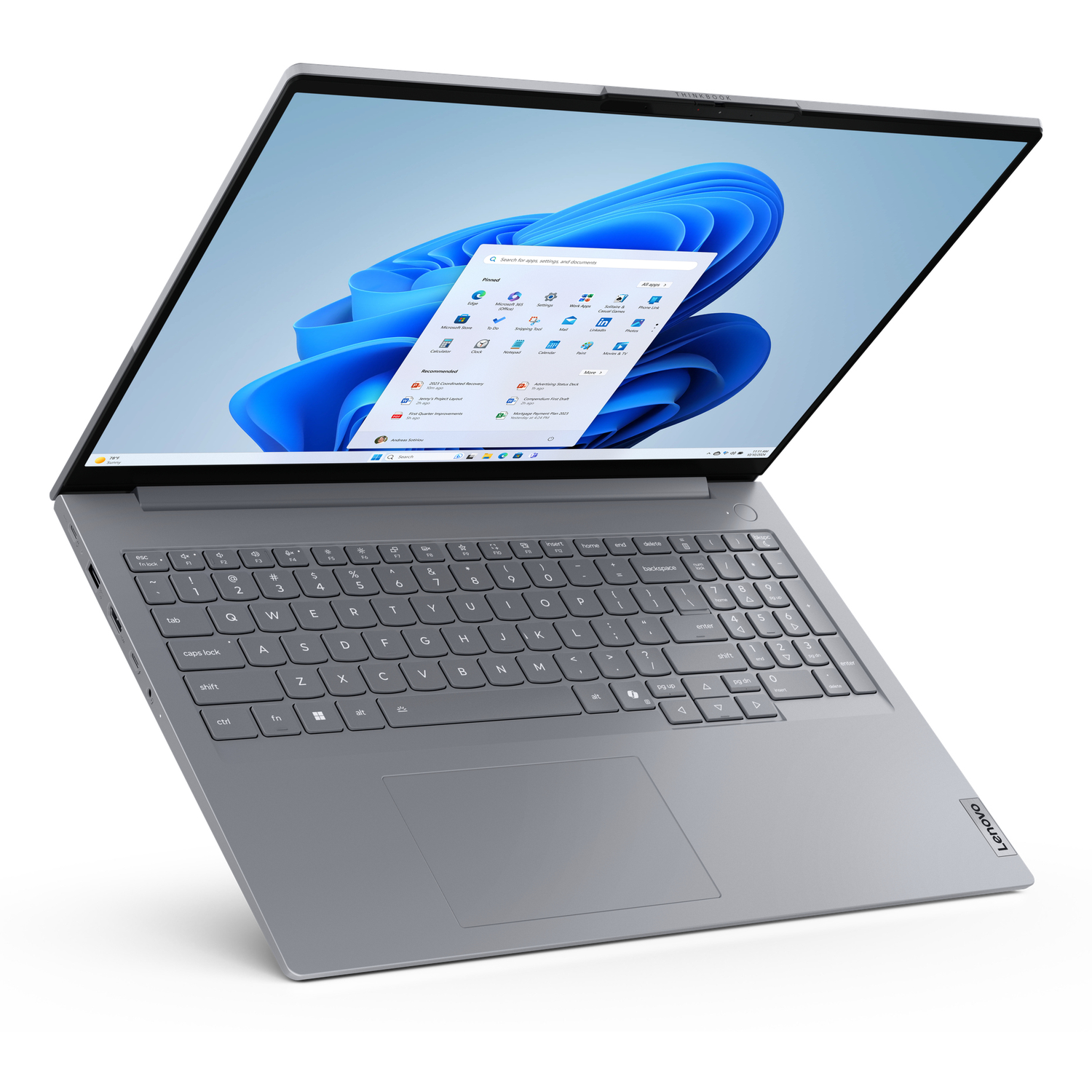 A gray Lenovo laptop is open, displaying the Windows 11 interface. The keyboard and trackpad are visible, set against a white background.