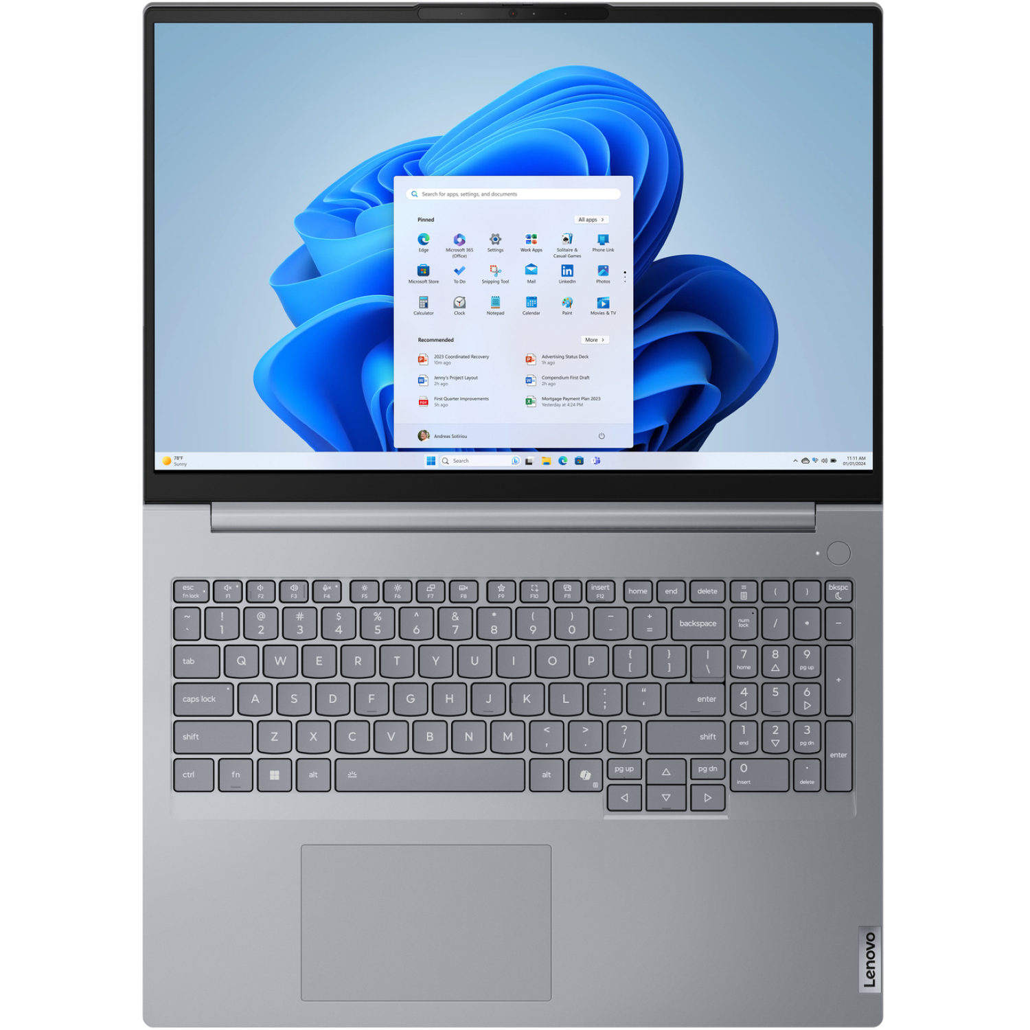 Silver Lenovo laptop with a Windows 11 interface open, showing apps. Keyboard visible.