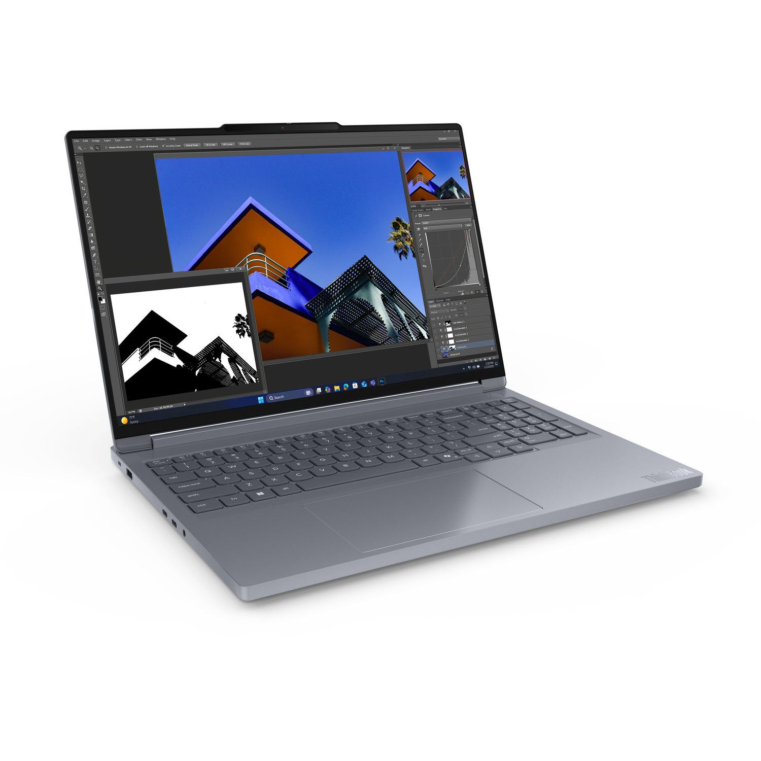 A gray laptop displays a photo editing software interface with a building image. The laptop is on a white surface.
