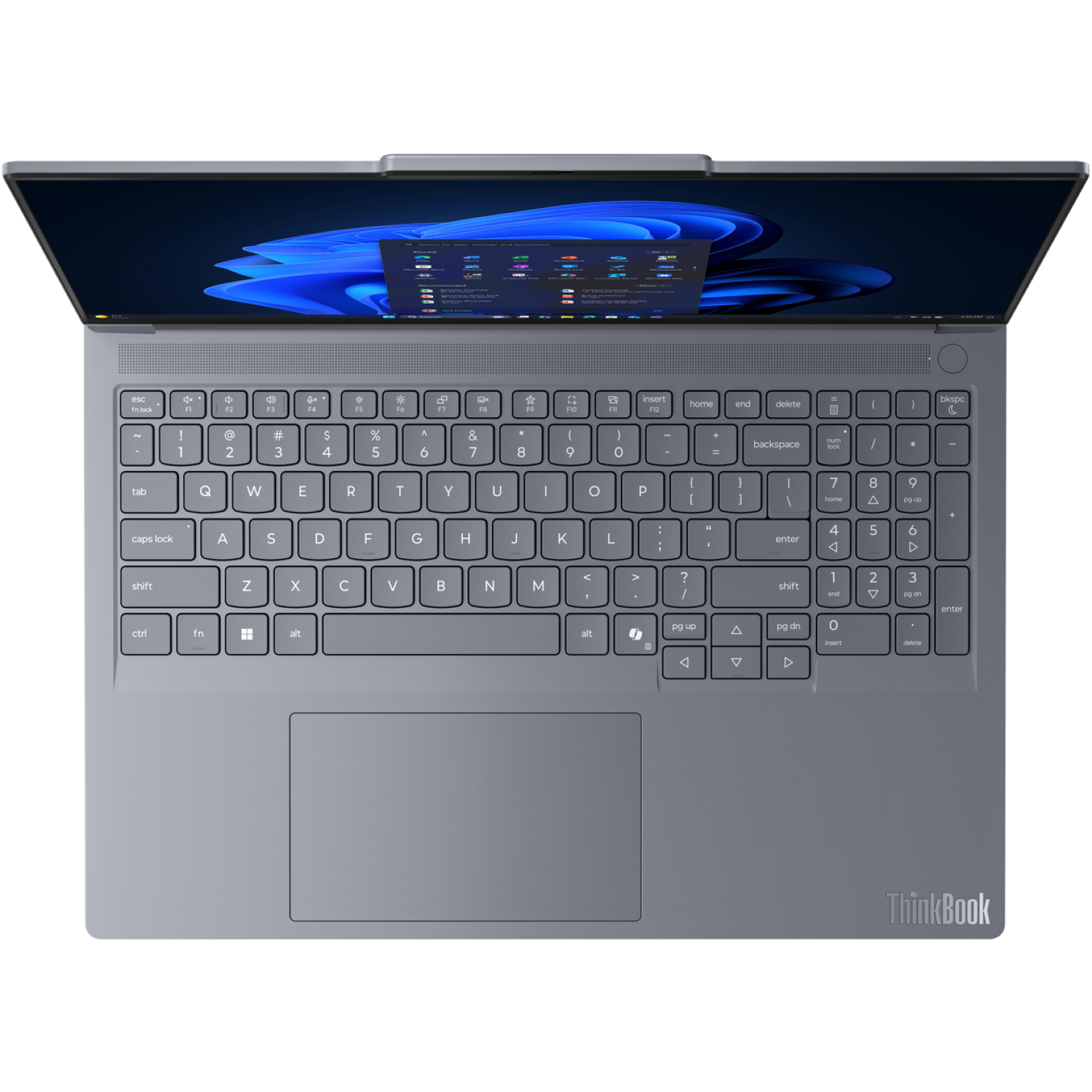 A grey ThinkBook laptop is open. The screen displays the Windows 11 interface. The keyboard is visible with various keys and a touchpad.