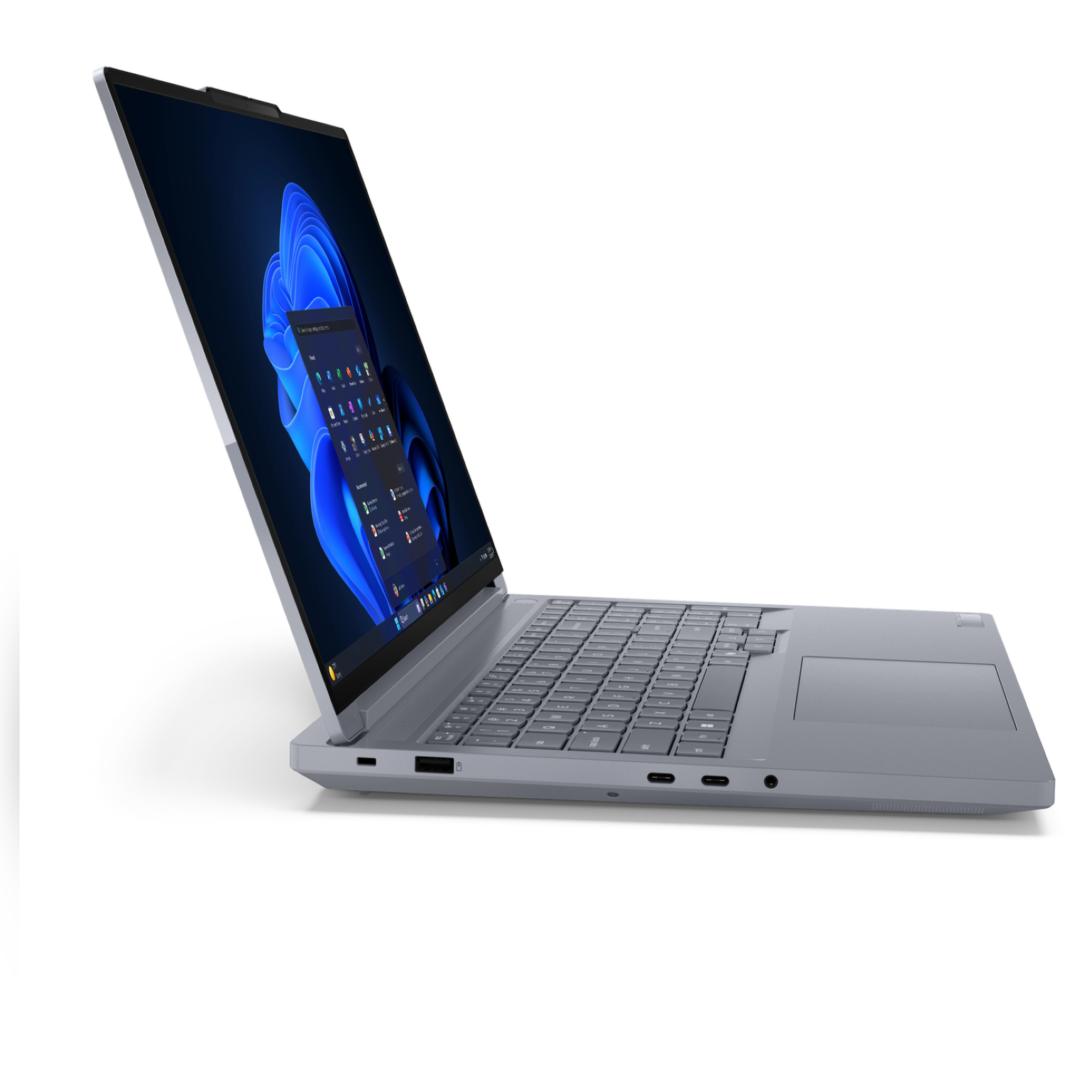 A gray laptop is open, displaying a Windows 11 interface. The screen shows a blue background. The laptop is on a white surface.