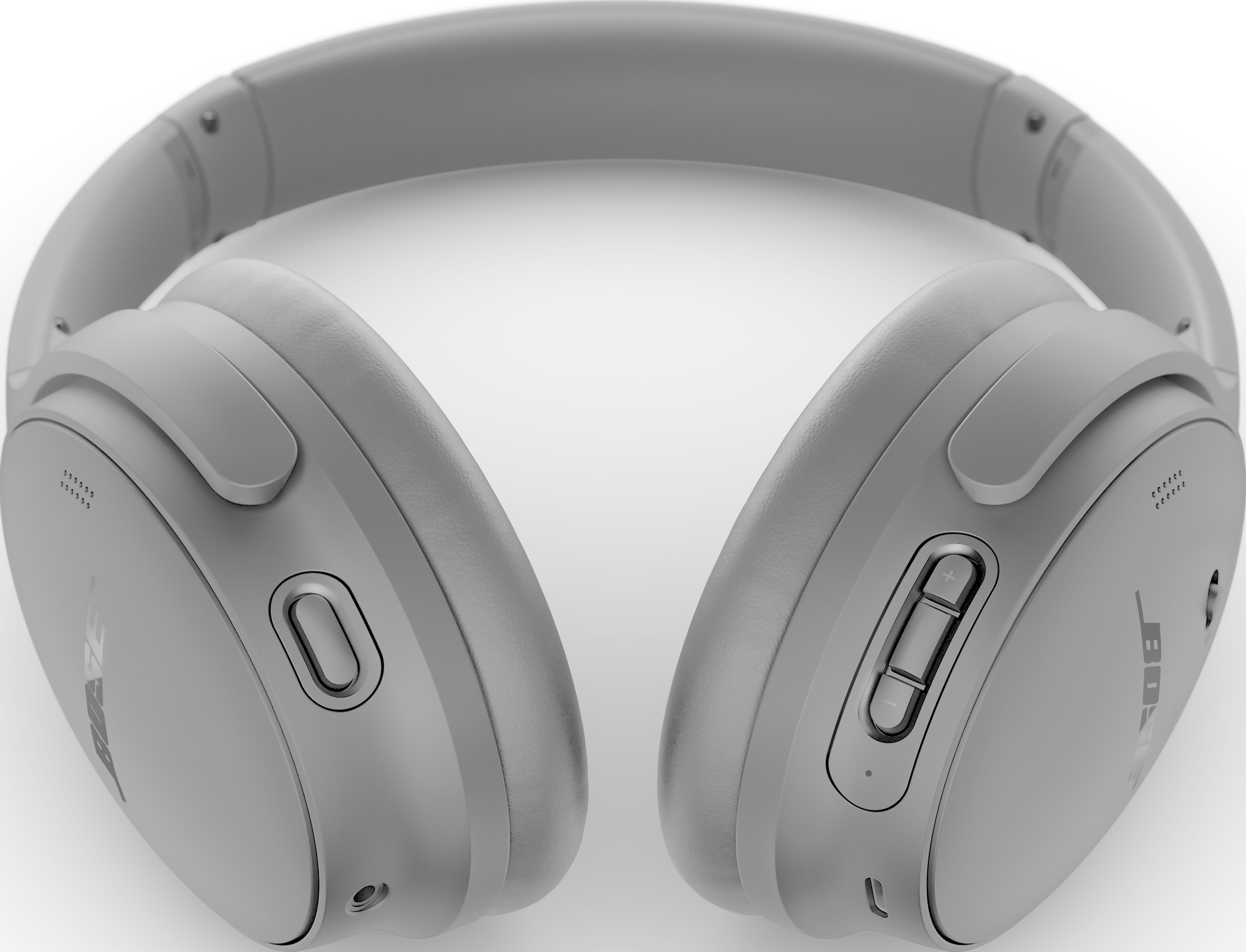 Une paire d'écouteurs gris, avec le logo Bose, sur fond noir. Des boutons sont visibles sur les oreillettes.