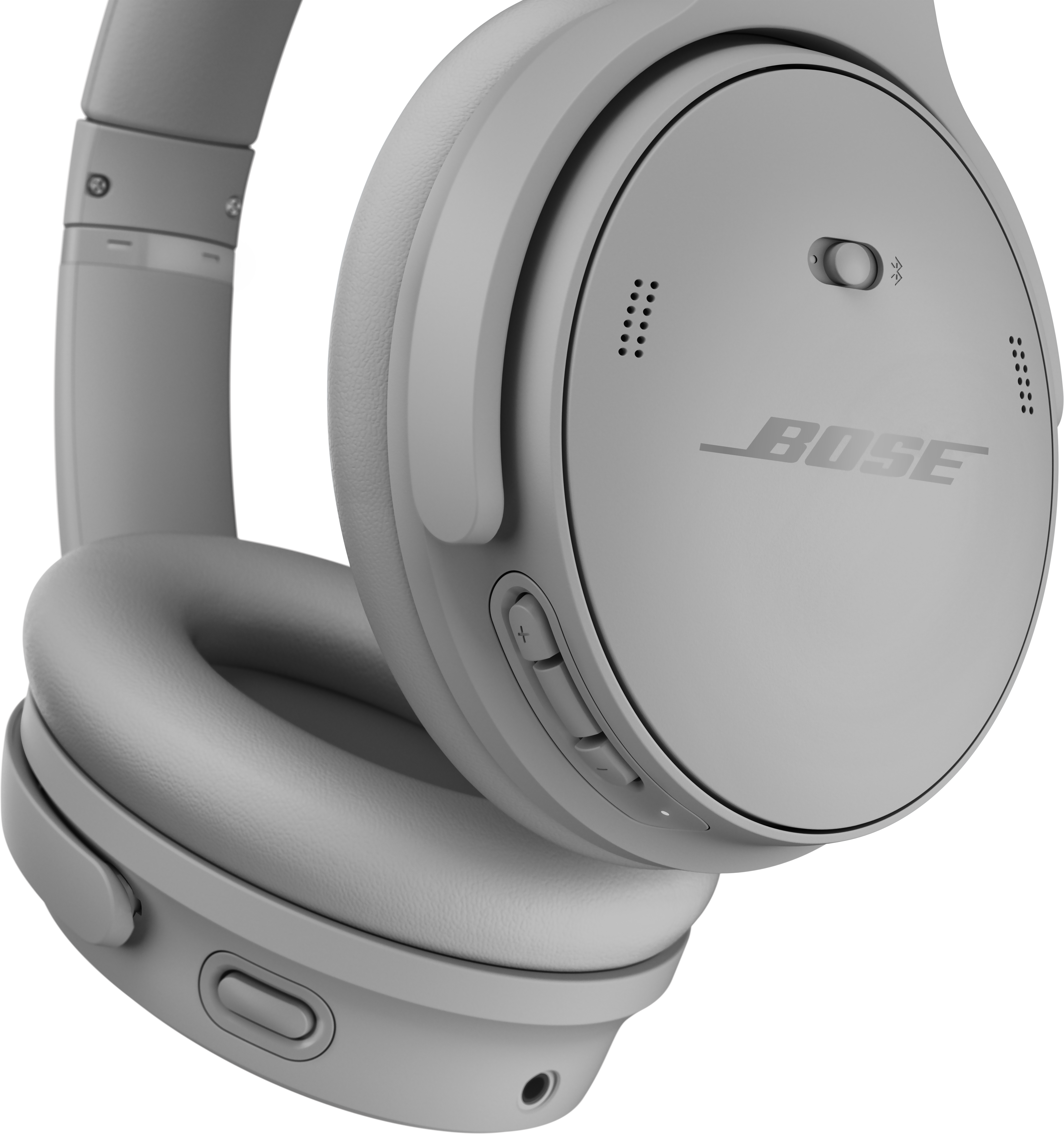 Gros plan sur un casque Bose gris. Oreillettes, serre-tête et commandes visibles. Le logo Bose est imprimé.