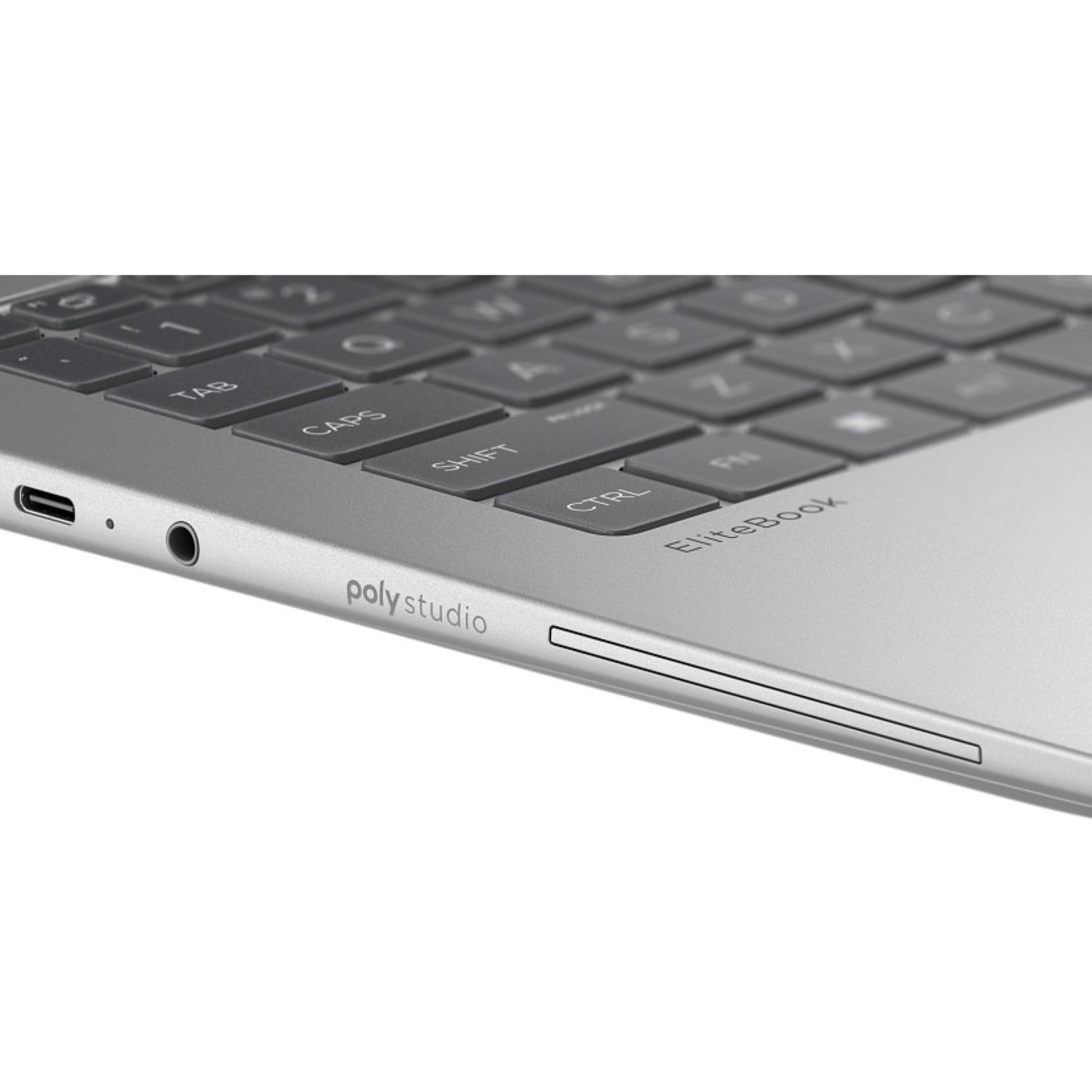 Een zilveren laptop met toetsenbord en randen is zichtbaar. Het toetsenbord heeft grijze toetsen. De rand van de laptop heeft poorten en het 'poly studio'-logo.