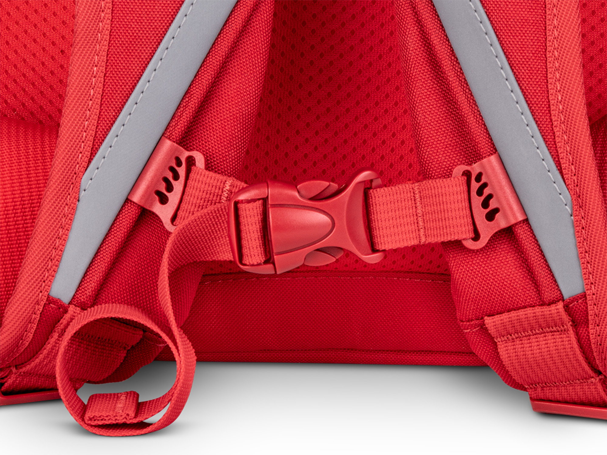 Nahaufnahme der Rückseite eines roten Rucksacks. Sichtbar sind Gurte, Schnallen und reflektierende graue Streifen, alles vor weißem Hintergrund.