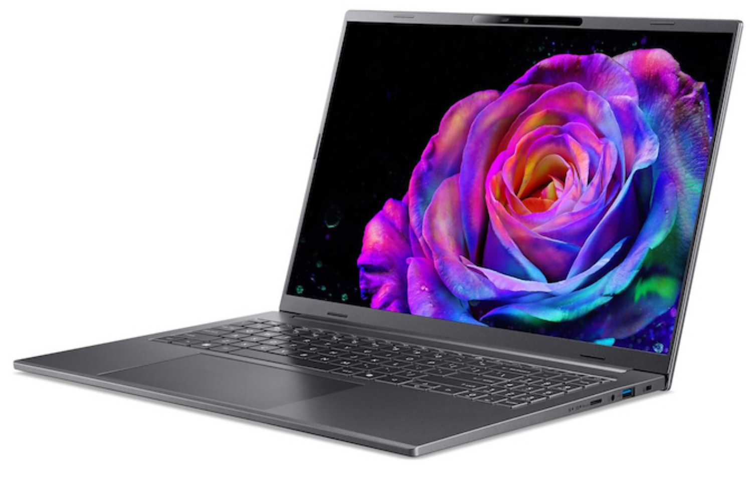 Un portátil gris muestra una colorida rosa sobre un fondo negro. El portátil está ligeramente abierto sobre una superficie blanca.