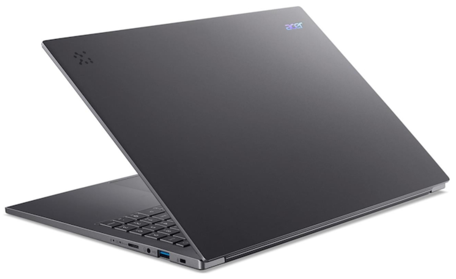 Una laptop Acer gris oscuro está abierta, en ángulo hacia el espectador. El teclado y los puertos son visibles. El logotipo de Acer está en la tapa.