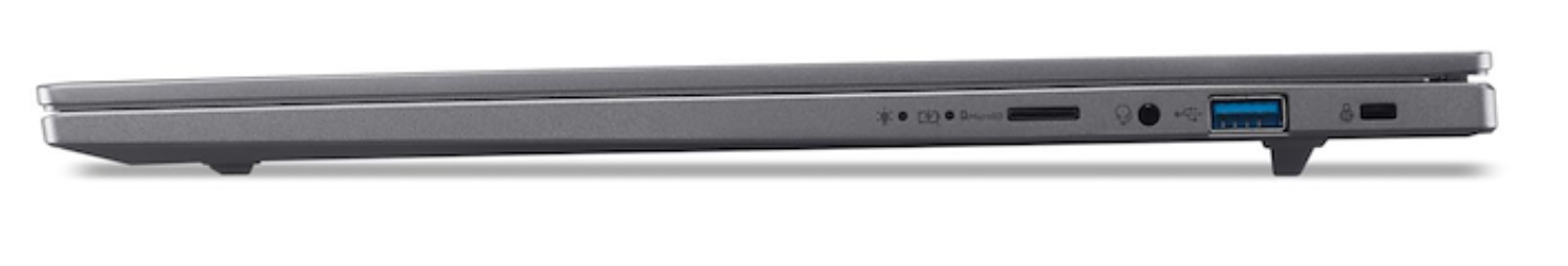 Vista lateral de un portátil gris. Los puertos visibles incluyen USB, conector de audio y ranura para tarjeta SD. El portátil está cerrado y apoyado en dos pequeños pies.