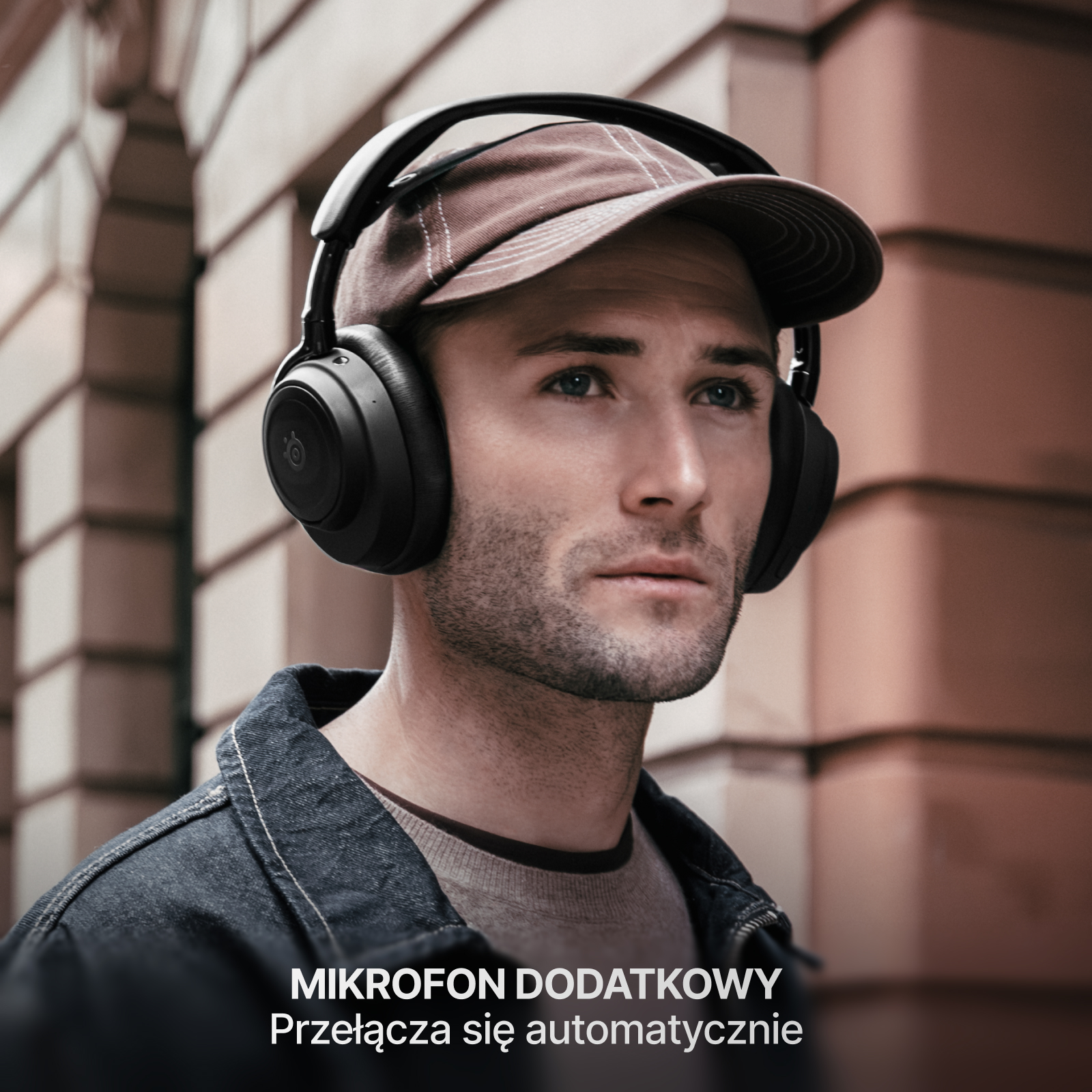 Mężczyzna w słuchawkach i czapce, patrzy w górę. Tło to ceglana ściana. Tekst na dole.