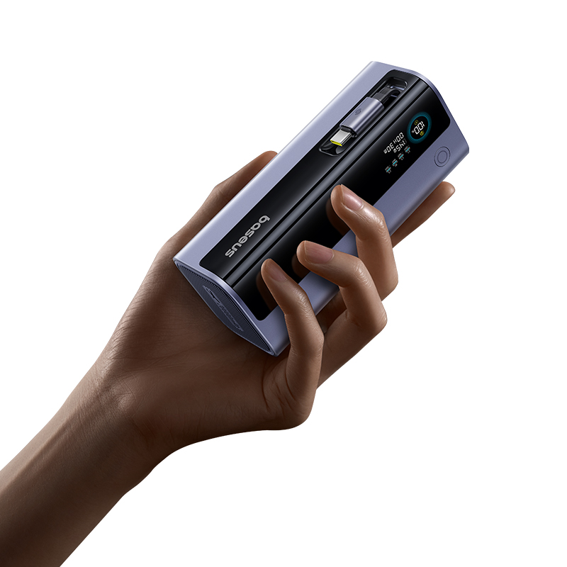 Bir el, mavi ve siyah bir Baseus powerbank tutuyor. Ekran pil bilgilerini gösteriyor. Bir USB-C kablosu kısmen takılı.