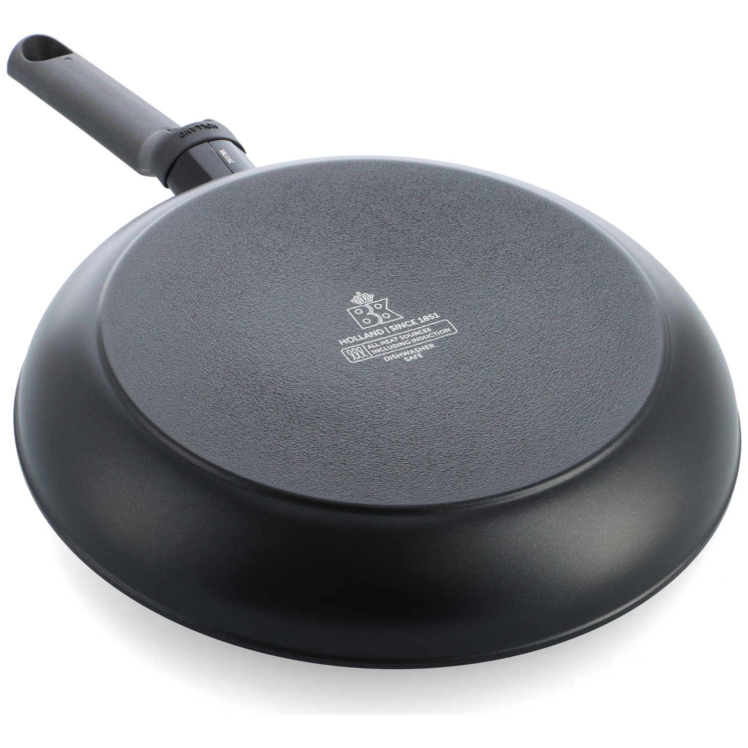 A black frying pan, underside facing up, with a gray handle. The base has a textured surface and brand details.