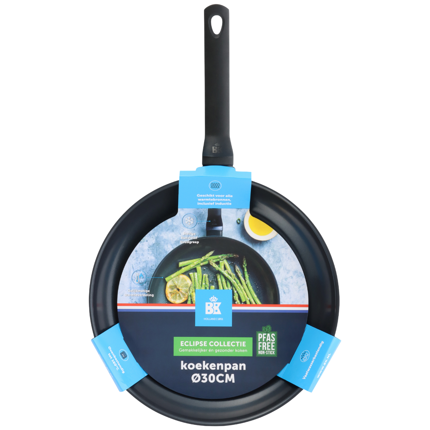 A black frying pan with a long handle is shown from above. It has a label with text, and inside the pan are vegetables and lemon slices.