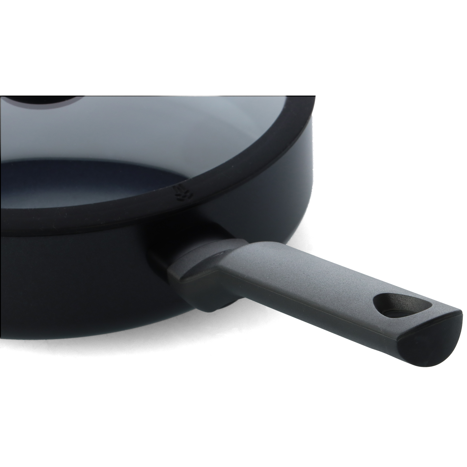 Close-up of a black frying pan with a gray handle. The pan is on a white background. The handle has a hole.