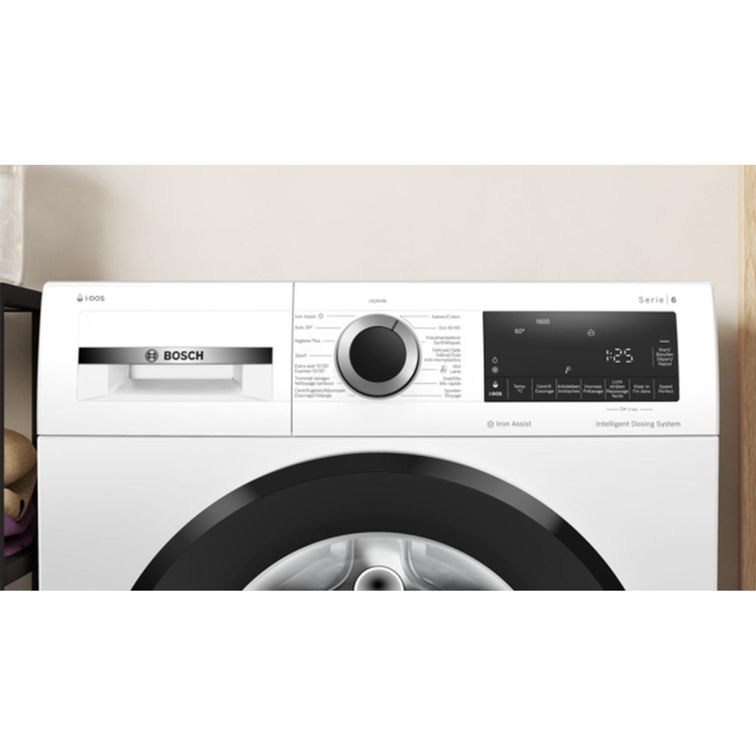 Een witte Bosch wasmachine met zwarte deur. Met bedieningspaneel en digitaal display. Lichte muur.