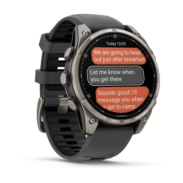 Egy Garmin okosóra szöveges üzeneteket jelenít meg. Az óra fekete és ezüst színű, fekete szíjjal, az időt és beszélgetési buborékokat mutat.