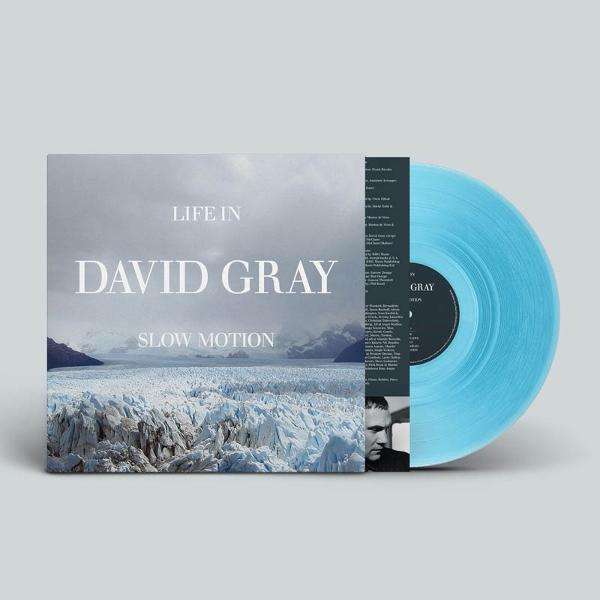 Albumcover von David Grays 'Life in Slow Motion' mit Gletscherbild. Auf der rechten Seite ist eine hellblaue Schallplatte zu sehen.