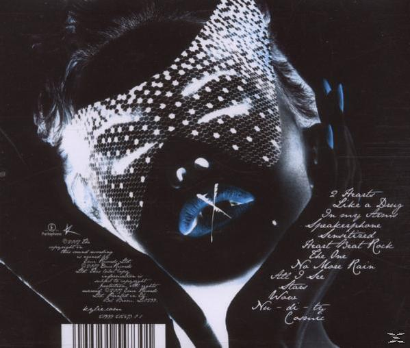 Albumcover. Das Gesicht einer Frau ist teilweise durch ein gepunktetes Muster verdeckt. Blaue Lippen und Nägel. Songtitel sind rechts aufgeführt.