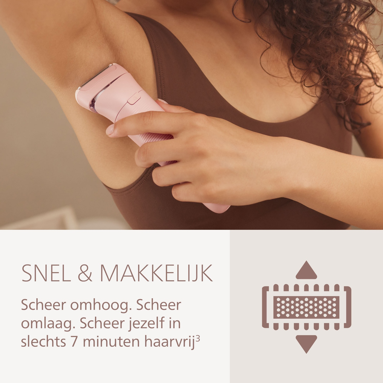 A woman shaves her underarm with a pink electric shaver. She wears a brown tank top. The background is light.