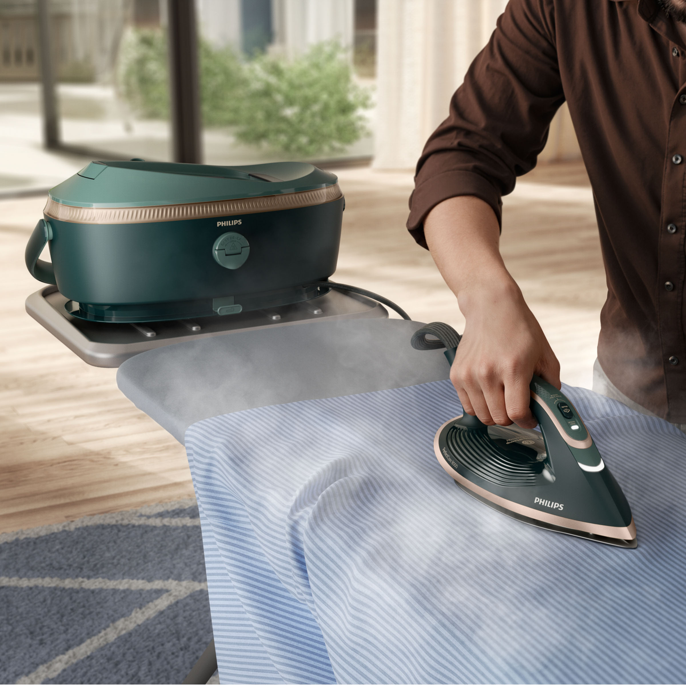 Osoba prasuje niebieską koszulę w paski zielonym żelazkiem. Para unosi się z żelazka. Widoczna zielona stacja prasowania.