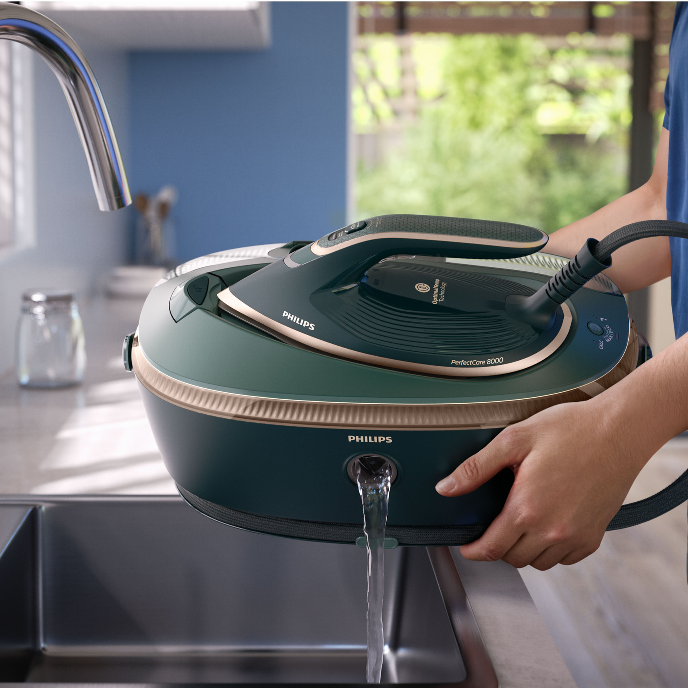 Osoba trzyma zielono-złote żelazko Philips PerfectCare 8000 nad zlewem, z którego wypływa woda.