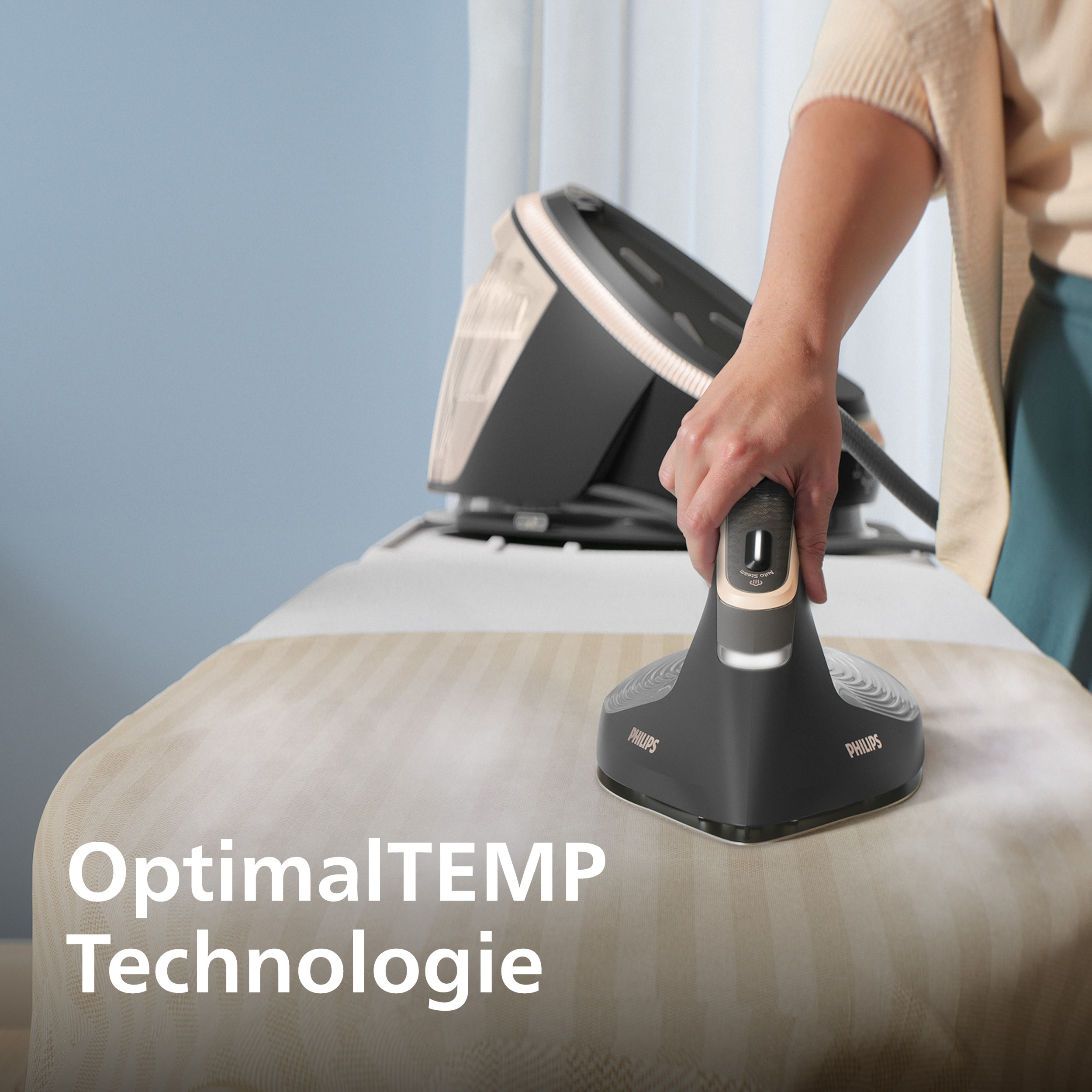 Eine Person bügelt mit einem Philips-Bügeleisen. Das Eisen ist schwarz und grau. Dampf ist sichtbar. Text: OptimalTEMP Technologie.