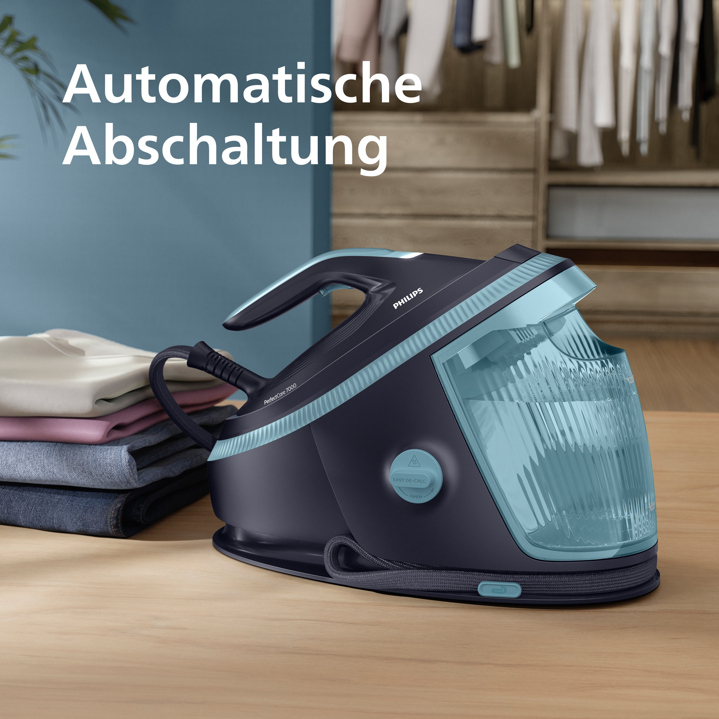 Ein Philips-Bügeleisen mit blauem Wassertank steht auf einem Holztisch. Links sind Kleidungsstücke.