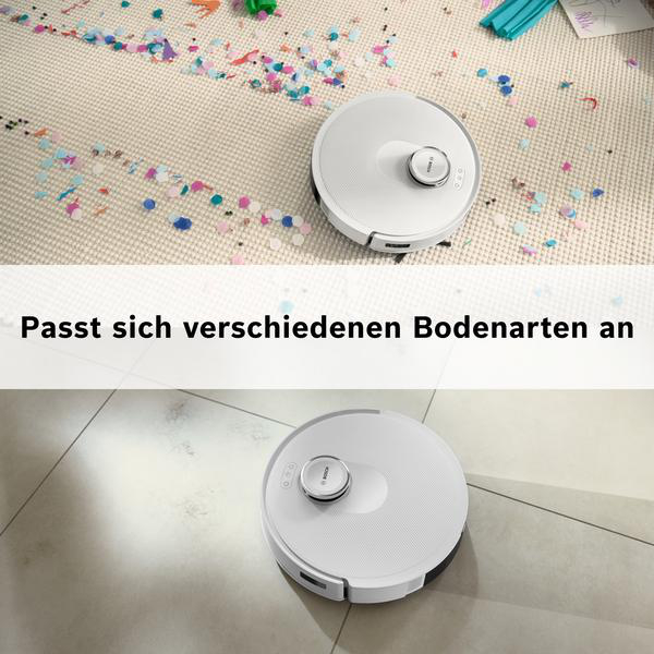 Zwei Roboter-Staubsauger. Einer auf einem Teppich mit Konfetti, der andere auf Fliesen. Text: Passt sich verschiedenen Bodenarten an.