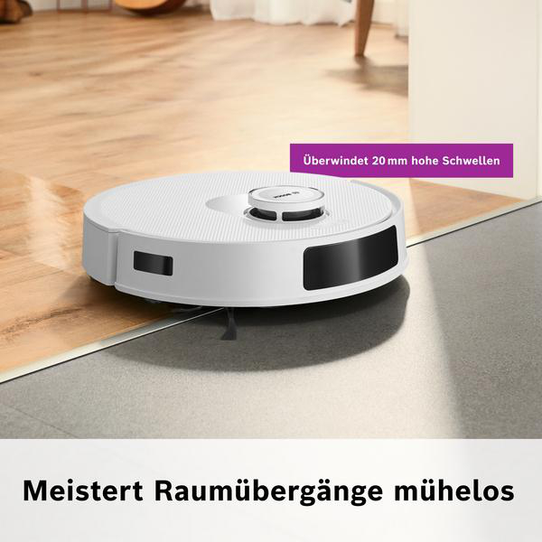 Ein weißer Roboter-Staubsauger auf einem Boden, der von Holz zu grauem Fliesen übergeht. Ein Textfeld besagt 'Überwindet 20 mm hohe Schwellen'.