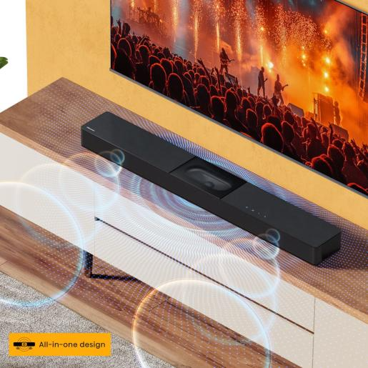 Egy fekete soundbar a koncert jelenetet mutató TV alatt. A soundbar egy fa felületen helyezkedik el.