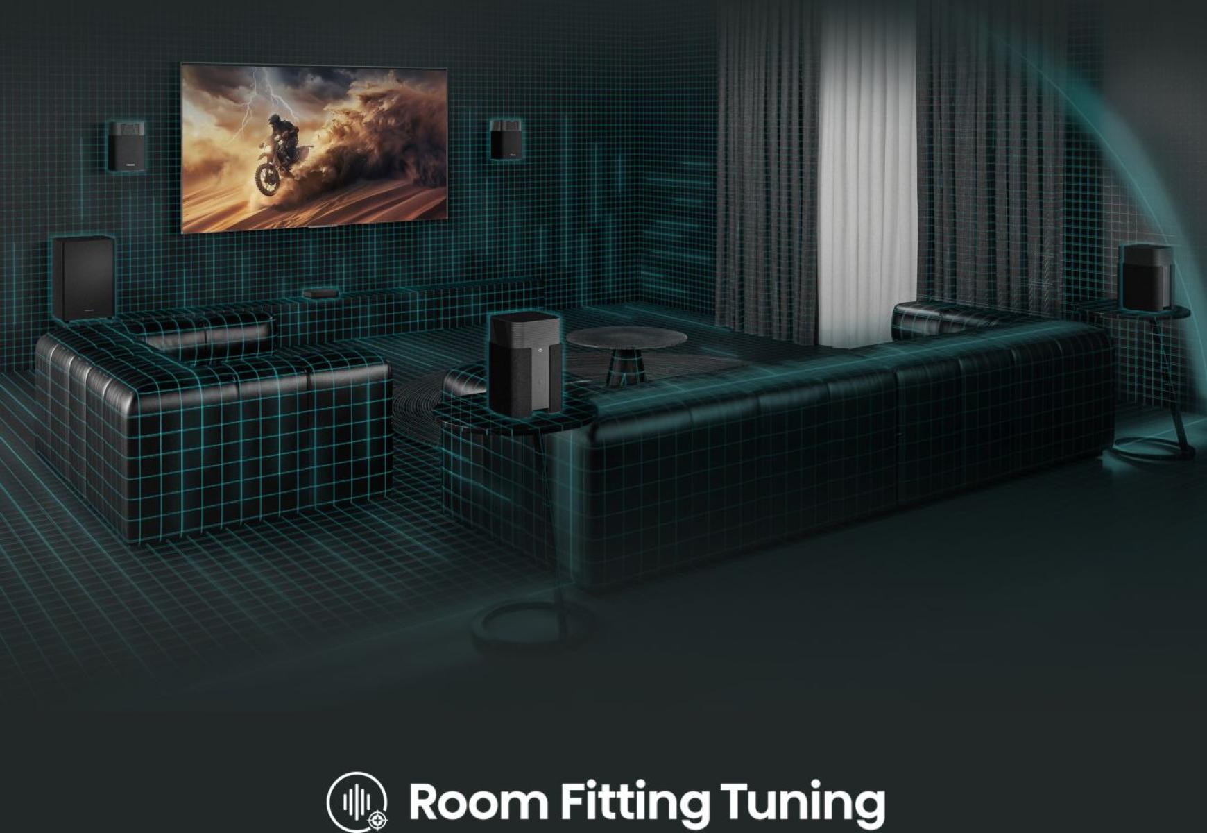 Modern nappali nagyméretű képernyővel, motocross jelenettel, hangszórókkal és egy nagy, fekete kanapéval. Room Fitting Tuning látható.