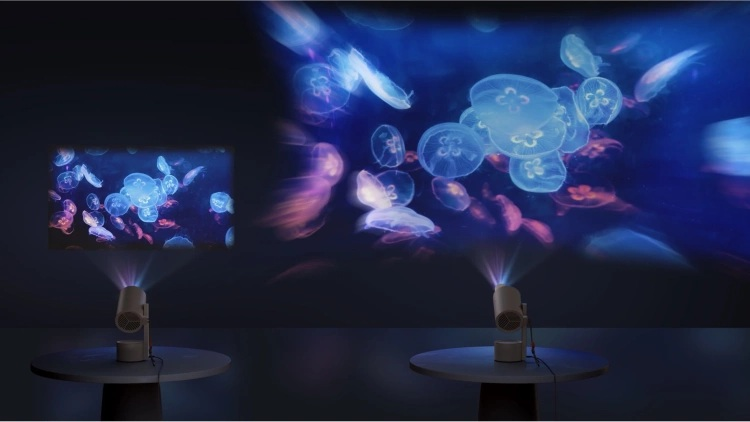 Projektory wyświetlają meduzy. Jeden wyświetla na ścianie, drugi na suficie. Oba są na okrągłych stołach w ciemnym pokoju.