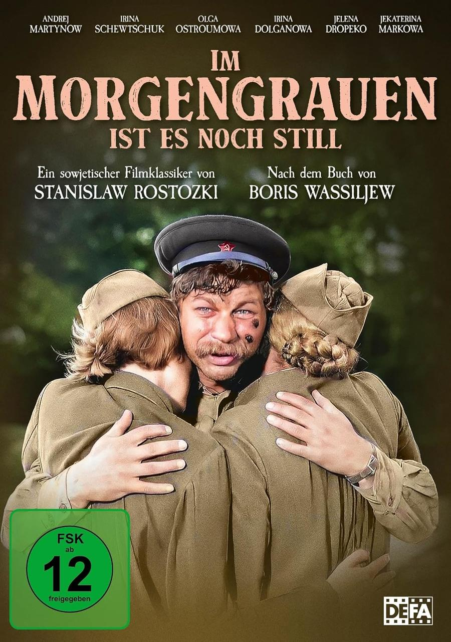 Filmposter: Drei Personen in Militäruniformen umarmen sich. Titel 'Im Morgengrauen'. Grünes Bewertungsschild und DEFA-Logo sichtbar.