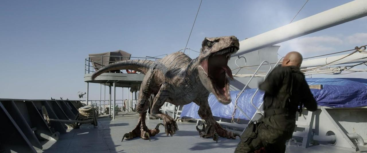Ein Dinosaurier mit offenem Mund brüllt auf einem Schiffsdeck. Ein Mann in Schwarz rennt weg.