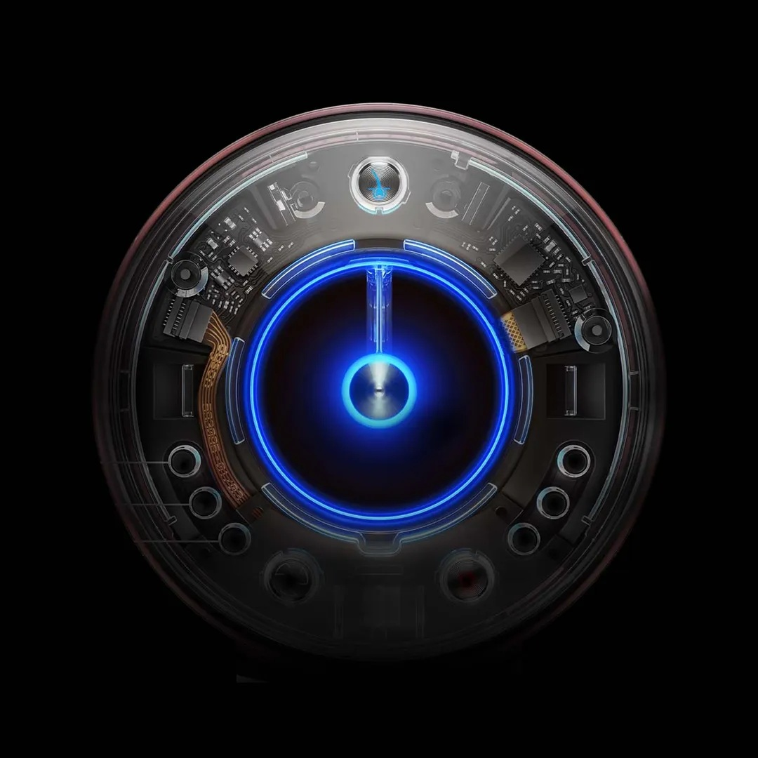 Zbliżenie okrągłego urządzenia z niebieskim świecącym pierścieniem, otoczone komponentami elektronicznymi, na czarnym tle.