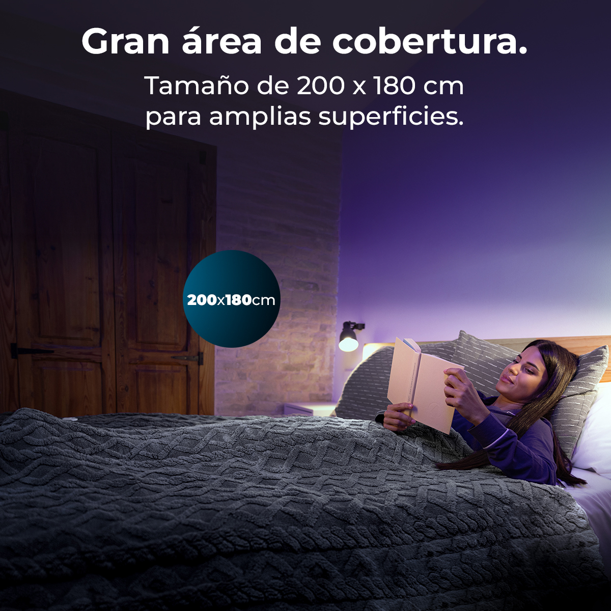 Mujer leyendo en la cama bajo una manta gris. Se ven un libro, una lámpara, una puerta de madera y texto de tamaño de la manta.