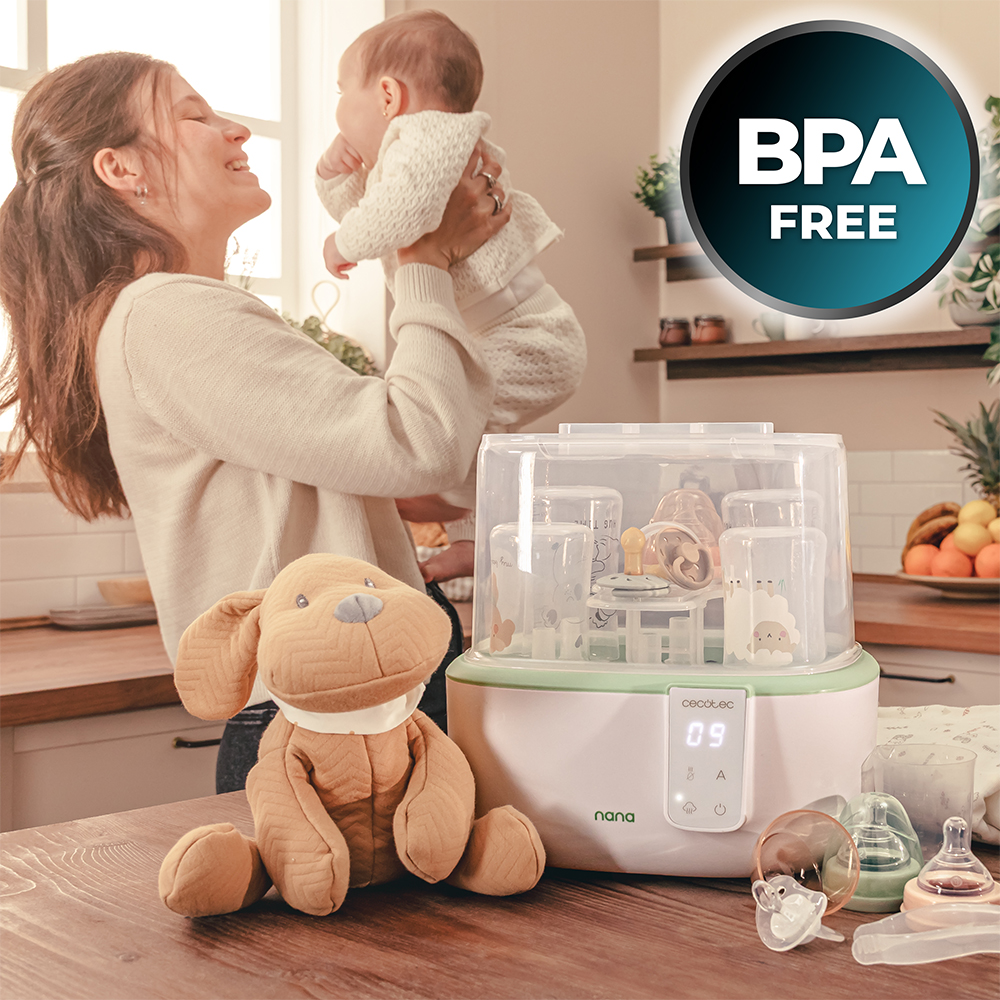Una madre sostiene a un bebé. Un esterilizador, biberones y un perro de peluche están en una mesa. El logo BPA Free está arriba a la derecha.